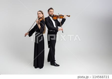 Bearded man and young woman violinist playing classical music at concert Bearded man and young woman violinist playing classical music at concert 114568721