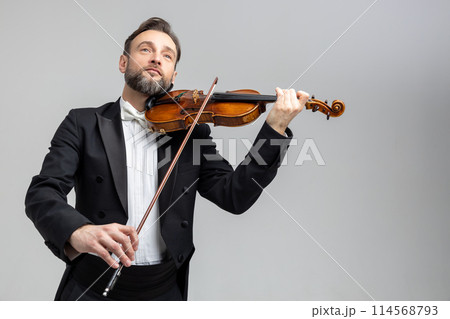 Elegant violinist playing passionately at concert 114568793