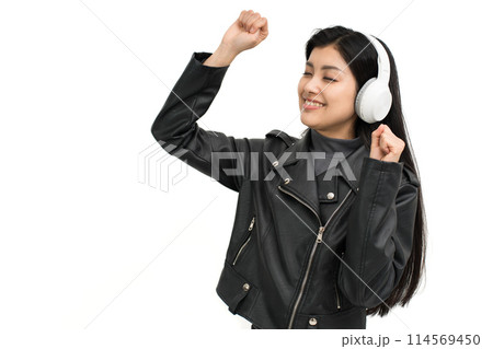 ヘッドホンで音楽を聴いて盛り上がる革ジャンを着た若い女性 114569450