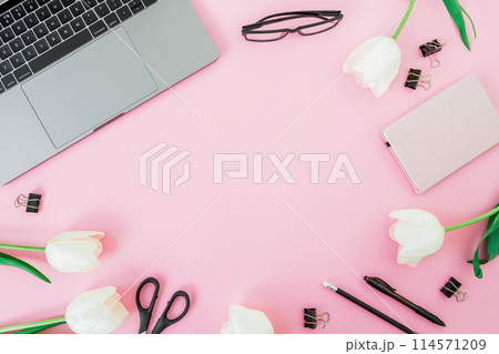 Office desk with laptop, flowers and pink diary on pink background. Flat lay. Freelance concept with copy space Office desk with laptop, flowers and pink diary on pink background. Flat lay. Freelance concept with copy space 114571209