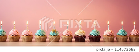 Colorful cupcakes with lit candles are displayed against a pink background, indicating an indoor celebration event marking of joy and celebrating. with free space 114572668