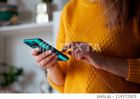 Woman using mobile phone, holding in hands 114572828