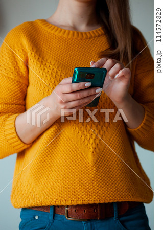 Woman using mobile phone, holding in hands 114572829