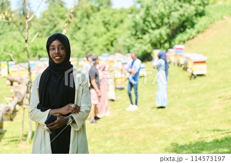 Empowered Middle Eastern Muslim Woman in Hijab Balances Modern Technology and Traditional Beekeeping Business Empowered Middle Eastern Muslim Woman in Hijab Balances Modern Technology and Traditional Beekeeping Business 114573197