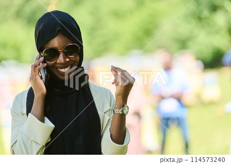 Empowered Middle Eastern Muslim Woman in Hijab Balances Modern Technology and Traditional Beekeeping Business 114573240