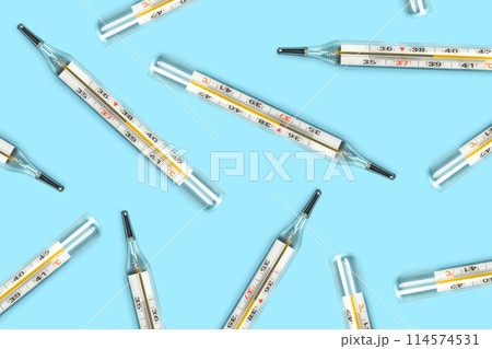 Mercury-in-glass thermometer creative pattern on blue background flat lay healthcare, treatment concept Mercury-in-glass thermometer creative pattern on blue background flat lay healthcare, treatment concept 114574531