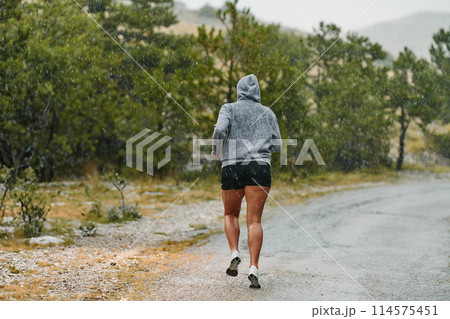 Unstoppable: A Determined Athlete Trains Through the Rain in Pursuit of Marathon Glory 114575451