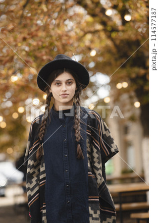 A sophisticated woman showcasing style in black attire and a hat. A sophisticated woman showcasing style in black attire and a hat. 114577187