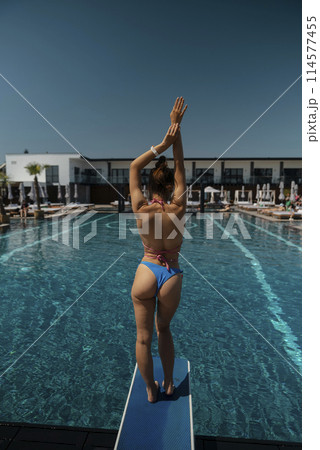 A captivating woman basks in the sunshine, looking stunning in her bikini. 114577455