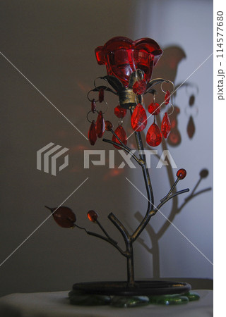 Candlestick in the shape of a flower.With a red bud and decorated with green stones. 114577680
