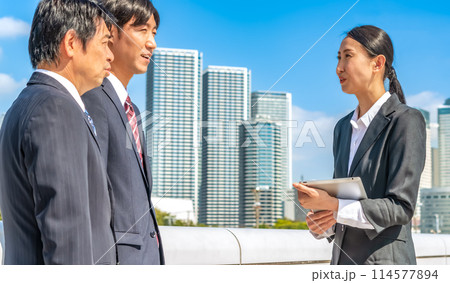東京をバックに話をするビジネスマンとビジネスウーマン 114577894