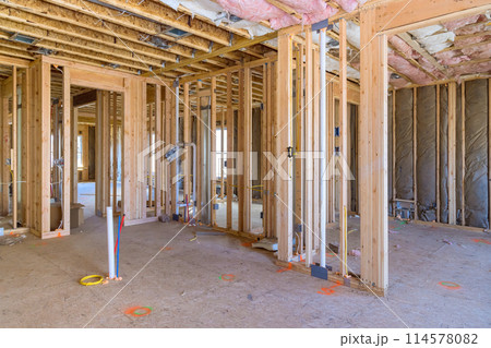 Under construction, new home is framing an unfinished wood frame with wooden trusses, posts, beams 114578082