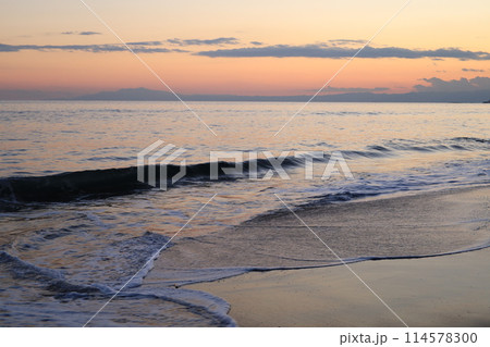 オレンジ色の夕日に輝く鎌倉七里ヶ浜の波打ち際のイメージ オレンジ色の夕日に輝く鎌倉七里ヶ浜の波打ち際のイメージ 114578300