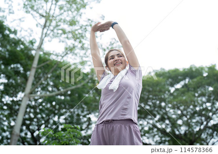 Asian woman stretching after a run in a park 114578366