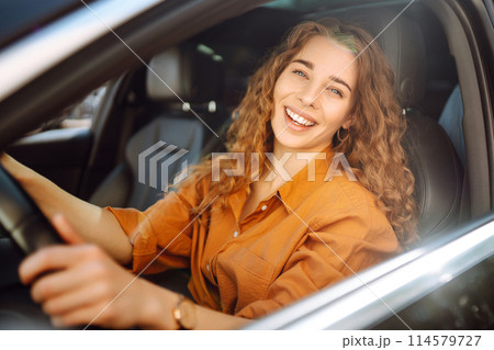 Smiling woman driving a car. Young traveler driving. Car travel, lifestyle concept. Smiling woman driving a car. Young traveler driving. Car travel, lifestyle concept. 114579727