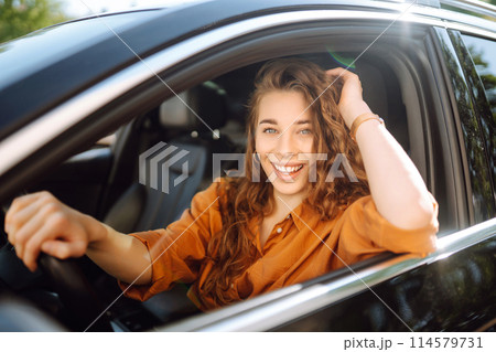 Smiling woman driving a car. Young traveler driving. Car travel, lifestyle concept. Smiling woman driving a car. Young traveler driving. Car travel, lifestyle concept. 114579731