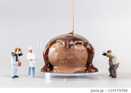 Professional confectioner making tasty chocolate dessert on gray background, World chocolate day concept Professional confectioner making tasty chocolate dessert on gray background, World chocolate day concept 114579766
