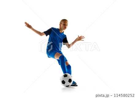 Teen girl showing her skills during football game, female soccer player practicing isolated on white studio background 114580252