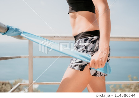 Woman sea pilates. Sporty happy middle aged woman practicing fitness on beach near sea, smiling active female training on yoga mat outside, enjoying healthy lifestyle, harmony and meditation. Woman sea pilates. Sporty happy middle aged woman practicing fitness on beach near sea, smiling active female training on yoga mat outside, enjoying healthy lifestyle, harmony and meditation. 114580544