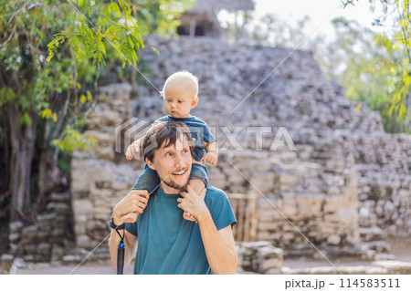 Dad and son tourists at Coba, Mexico. Ancient mayan city in Mexico. Coba is an archaeological area and a famous landmark of Yucatan Peninsula. Cloudy sky over a pyramid in Mexico 114583511