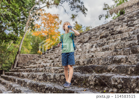 Boy tourist at Coba, Mexico. Ancient mayan city in Mexico. Coba is an archaeological area and a famous landmark of Yucatan Peninsula. Cloudy sky over a pyramid in Mexico Boy tourist at Coba, Mexico. Ancient mayan city in Mexico. Coba is an archaeological area and a famous landmark of Yucatan Peninsula. Cloudy sky over a pyramid in Mexico 114583515