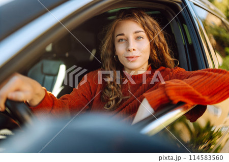 Young smiling woman driving a car drives around the city. Lifestyle concept. 114583560