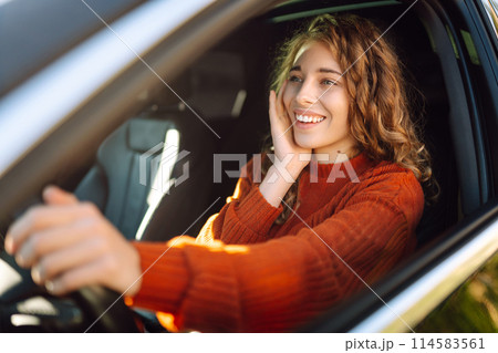 Young smiling woman driving a car drives around the city. Lifestyle concept. 114583561