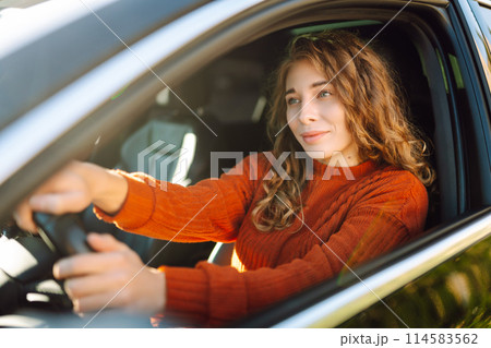 Young smiling woman driving a car drives around the city. Lifestyle concept. 114583562
