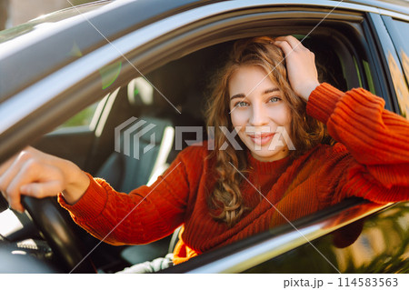 Young smiling woman driving a car drives around the city. Lifestyle concept. 114583563