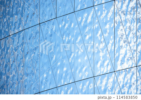 Shiny blue metal wall structure made of rippled steel plates 114583850
