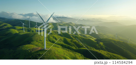 Wind turbines against the backdrop of green hills or fields. 114584294
