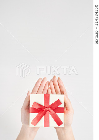 プレゼント用に包装された箱を持つ女性の手元 プレゼント用に包装された箱を持つ女性の手元 114584350