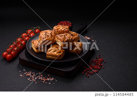 Triangular puffs with feta cheese, tomatoes with salt, spices and herbs Triangular puffs with feta cheese, tomatoes with salt, spices and herbs 114584485