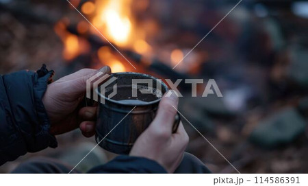 The close up picture of person holding cup of hot coffee near fireplace. AIG43. The close up picture of person holding cup of hot coffee near fireplace. AIG43. 114586391