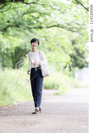 新緑の道を歩く若いビジネスウーマン 新緑の道を歩く若いビジネスウーマン 114588906