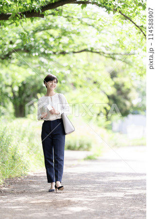 新緑の道を歩く若いビジネスウーマン 114588907
