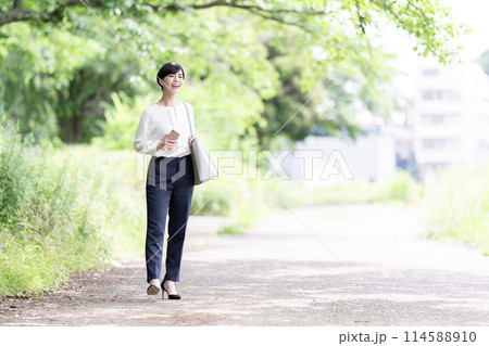 新緑の道を歩く若いビジネスウーマン 114588910