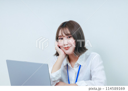 右手で頬杖をついた笑顔の若い女性 右手で頬杖をついた笑顔の若い女性 114589169