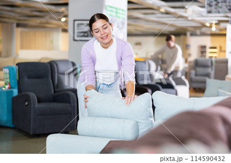 woman in furniture center chooses best sofa woman in furniture center chooses best sofa 114590432