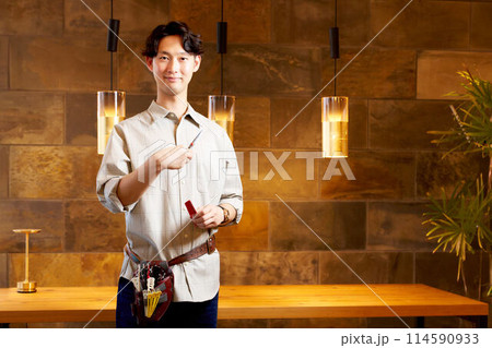 笑顔で視線を向ける若い男性美容師 114590933
