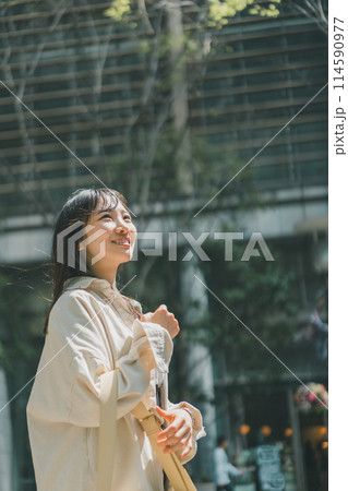 休日に都会を一人歩きする若い女性 114590977