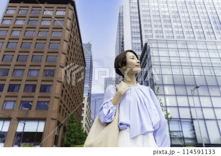 オフィス街に立つビジネスウーマン オフィス街に立つビジネスウーマン 114591133