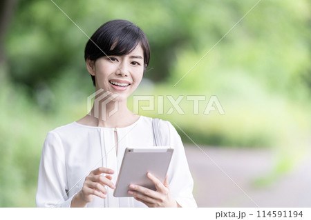 屋外でタブレットを操作するビジネスウーマン タブレットを使う若い女性 屋外でタブレットを操作するビジネスウーマン タブレットを使う若い女性 114591194