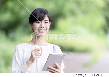 屋外でタブレットを操作するビジネスウーマン タブレットを使う若い女性 屋外でタブレットを操作するビジネスウーマン タブレットを使う若い女性 114591195