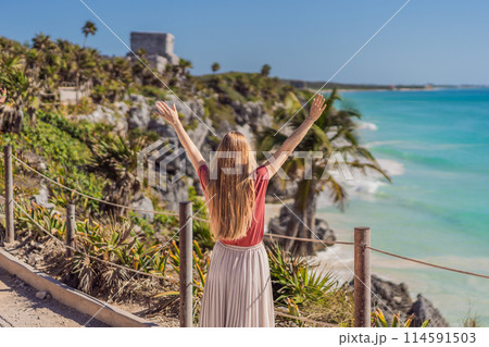 Woman tourist enjoying the view Pre-Columbian Mayan walled city of Tulum, Quintana Roo, Mexico, North America, Tulum, Mexico. El Castillo - castle the Mayan city of Tulum main temple Woman tourist enjoying the view Pre-Columbian Mayan walled city of Tulum, Quintana Roo, Mexico, North America, Tulum, Mexico. El Castillo - castle the Mayan city of Tulum main temple 114591503