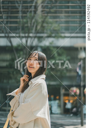 休日に都会を一人でウインドーショッピングをする若い女性 休日に都会を一人でウインドーショッピングをする若い女性 114592492