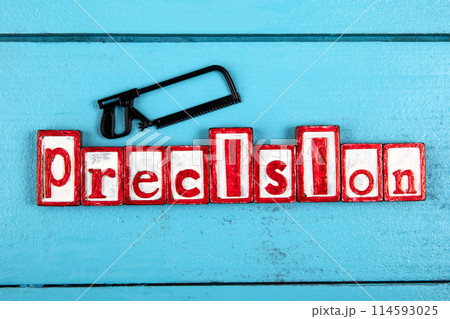 PRECISION. Miniature saw on a blue wooden background. Construction and carpentry concept 114593025