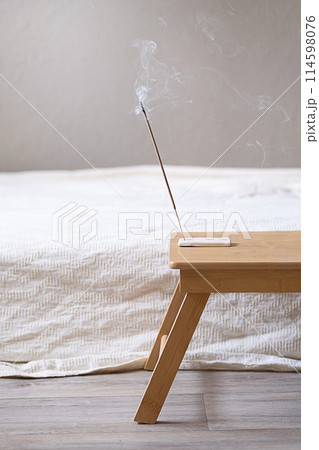 Burning incense stick on wooden table. Burning incense stick on wooden table. 114598076
