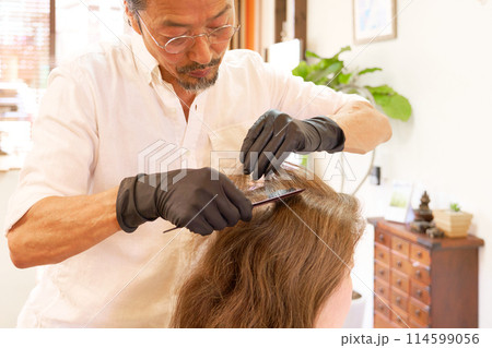 カラーリングを行う美容師と女性客 114599056