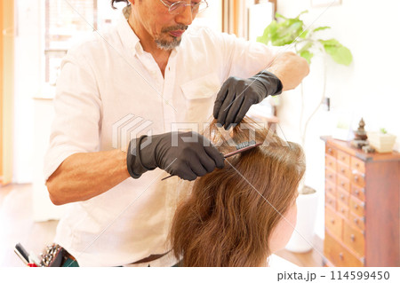 カラーリングを行う美容師と女性客 114599450